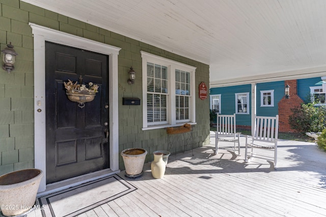 view of exterior entry featuring covered porch