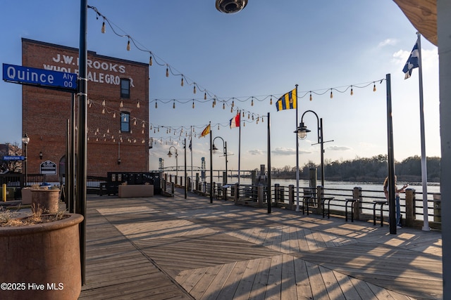 deck at dusk featuring a water view