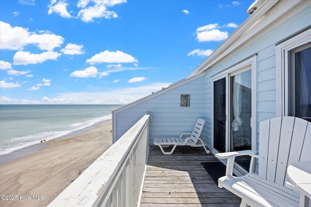 balcony with a deck with water view and a beach view