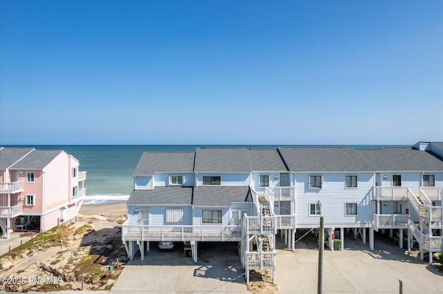 exterior space featuring a water view and a beach view