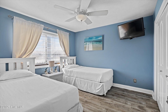 bedroom featuring a textured ceiling, a closet, dark wood-type flooring, and ceiling fan