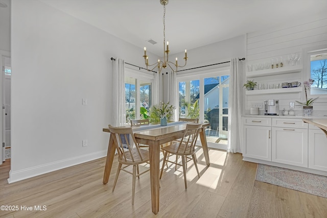 dining room with a chandelier and light hardwood / wood-style floors