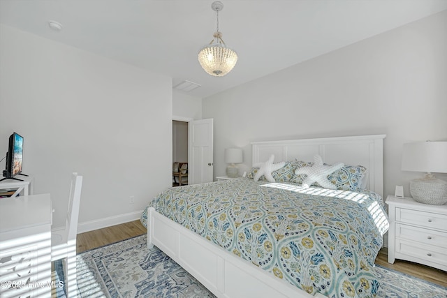 bedroom featuring light hardwood / wood-style flooring and a notable chandelier