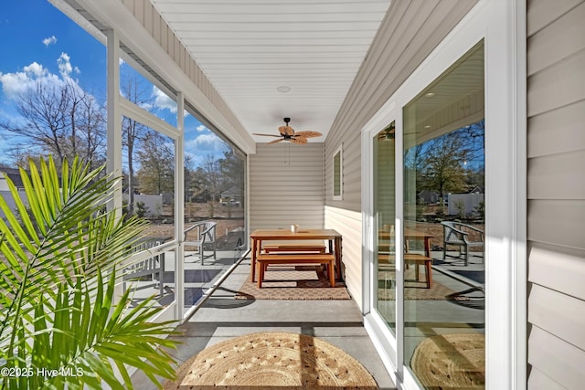 unfurnished sunroom with ceiling fan