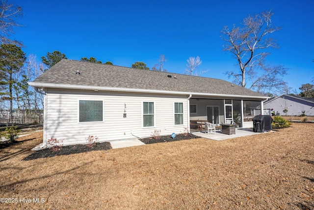 back of property with a sunroom, a yard, a patio, and an outdoor fire pit