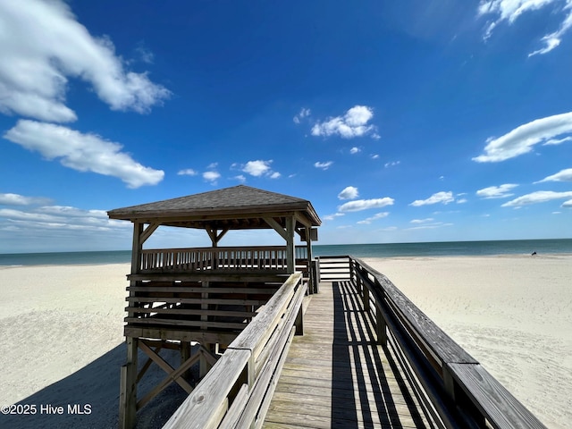 surrounding community with a beach view, a gazebo, and a water view