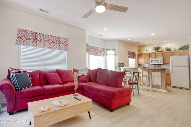 living room featuring ceiling fan and light hardwood / wood-style flooring