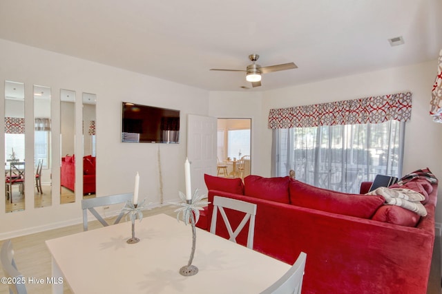 living room with ceiling fan and light wood-type flooring