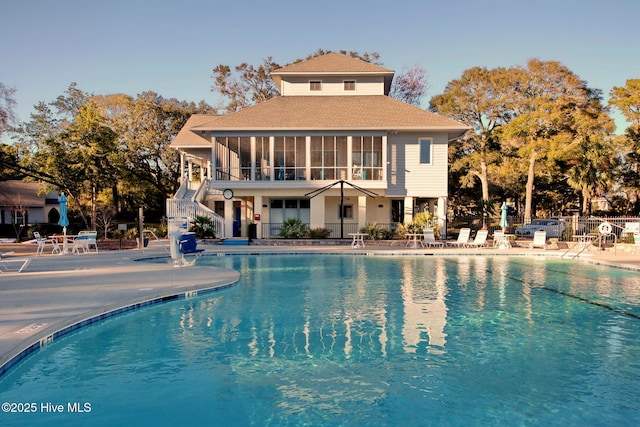 rear view of property with a community pool and a patio