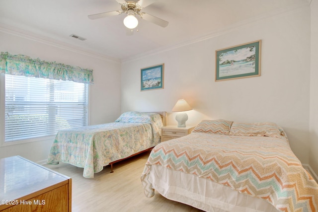 bedroom with ceiling fan, crown molding, and light hardwood / wood-style floors