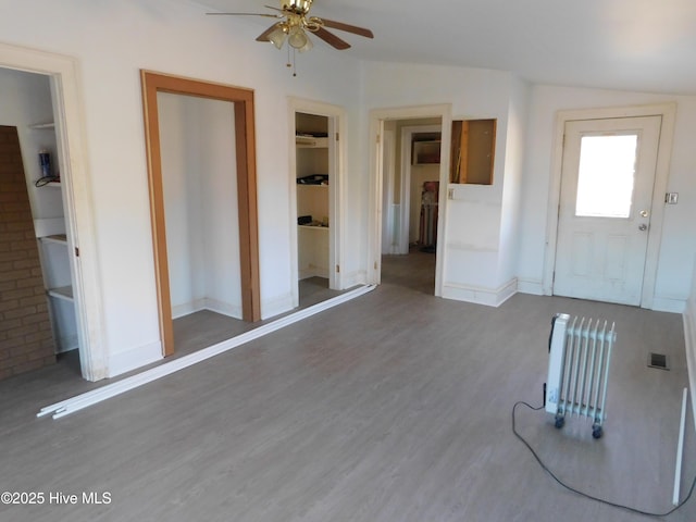 unfurnished living room with ceiling fan, hardwood / wood-style floors, and vaulted ceiling