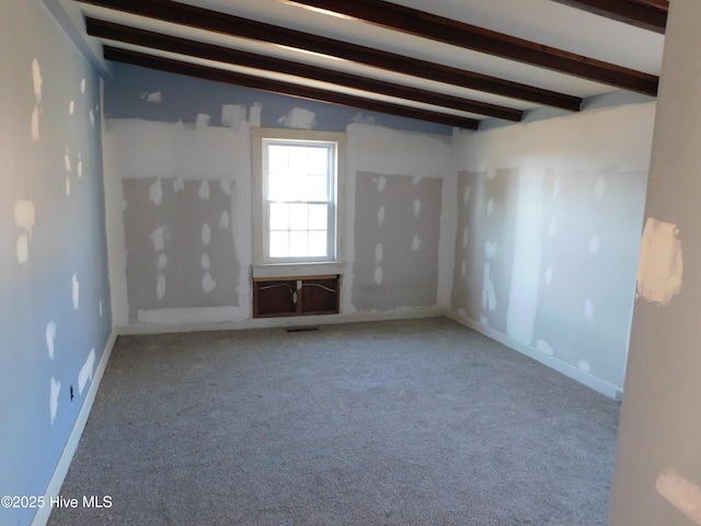 empty room with vaulted ceiling with beams and light carpet