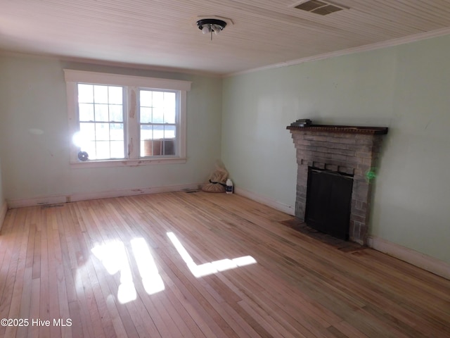 unfurnished living room featuring a stone fireplace, light hardwood / wood-style floors, and ornamental molding