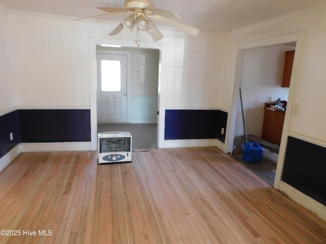 unfurnished living room with light wood-type flooring, heating unit, and ceiling fan