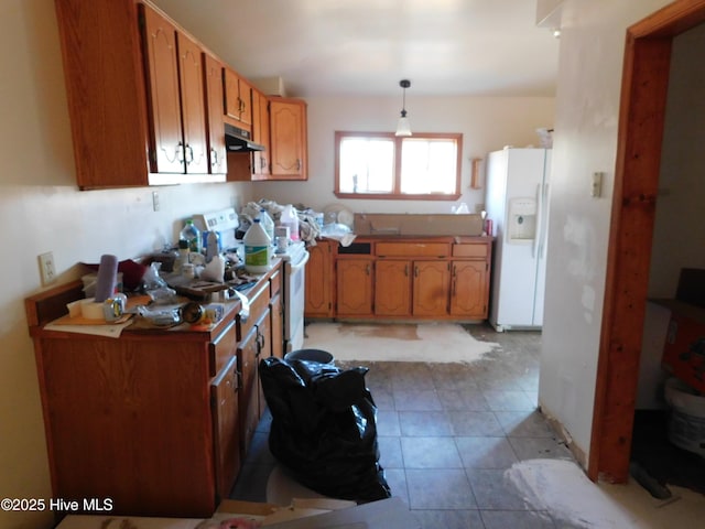 kitchen featuring decorative light fixtures and white refrigerator with ice dispenser