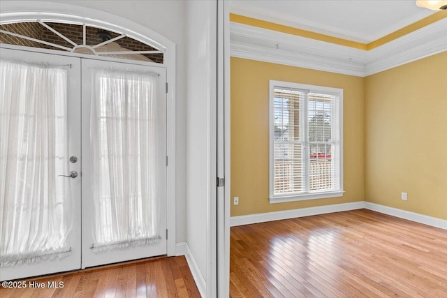 entrance foyer featuring crown molding, light hardwood / wood-style flooring, and french doors