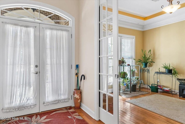 entryway with french doors, wood-type flooring, and crown molding