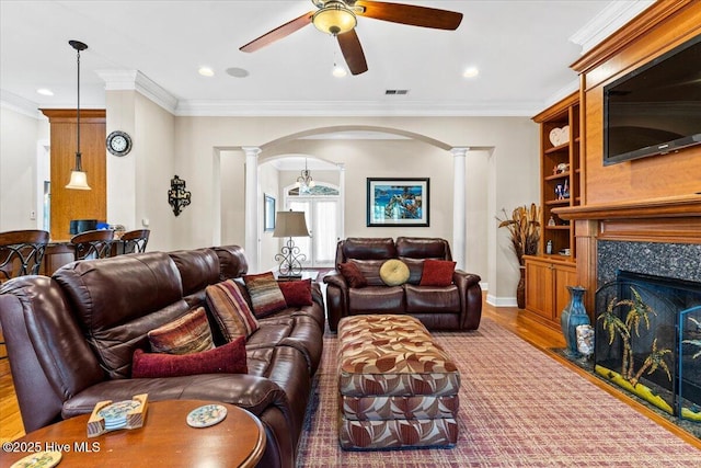 living room with ceiling fan, ornamental molding, decorative columns, and wood-type flooring