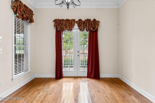 doorway with hardwood / wood-style floors, ornamental molding, french doors, and a healthy amount of sunlight