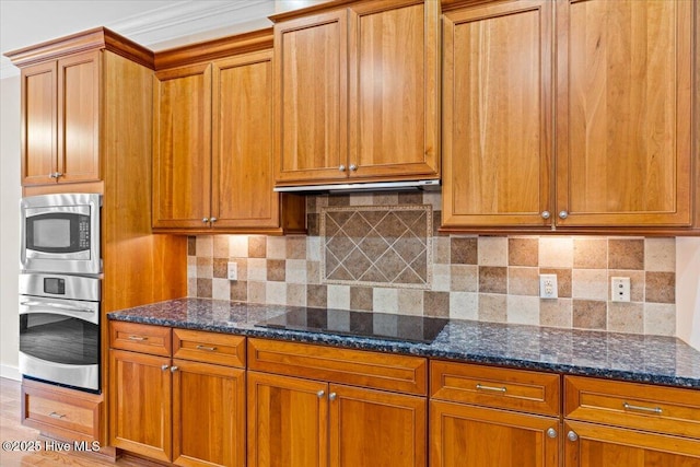 kitchen featuring dark stone countertops, tasteful backsplash, and appliances with stainless steel finishes