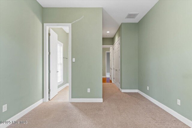 unfurnished bedroom featuring light carpet