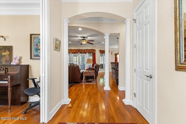 hall featuring crown molding, decorative columns, and hardwood / wood-style flooring