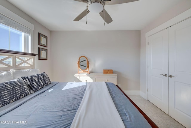 carpeted bedroom with ceiling fan and a closet