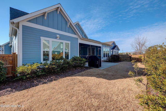 rear view of house with a sunroom and a patio