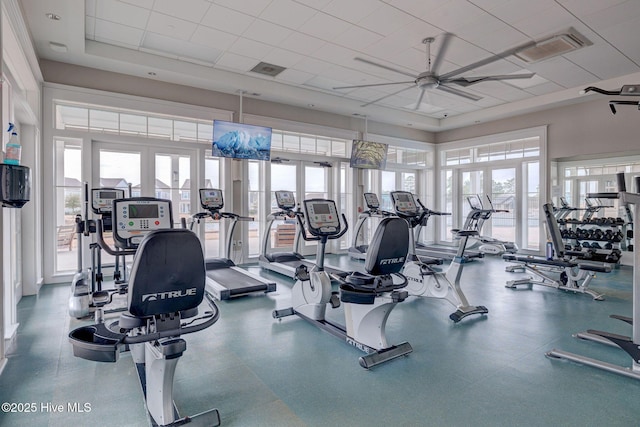 exercise room featuring ceiling fan, a raised ceiling, and french doors