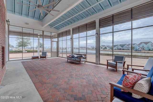 sunroom / solarium featuring a wealth of natural light, vaulted ceiling with beams, and ceiling fan