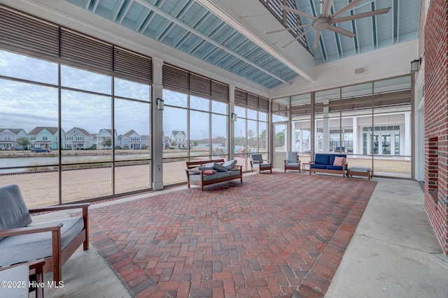 sunroom / solarium featuring ceiling fan and beamed ceiling