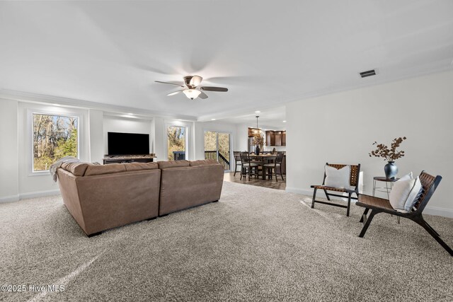 living room featuring carpet floors, ceiling fan, and crown molding