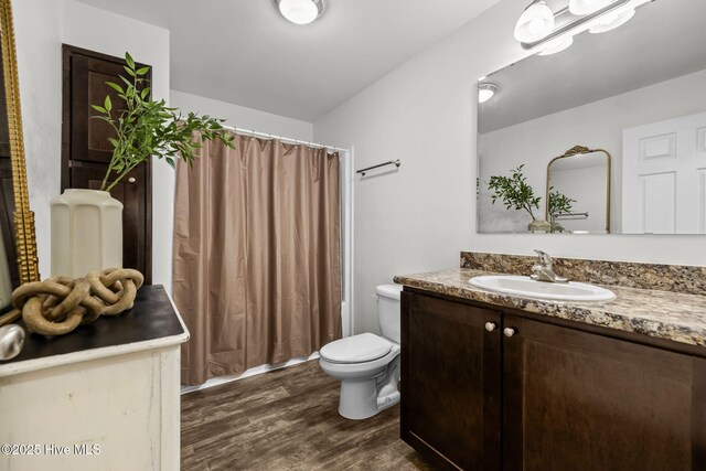 bathroom featuring hardwood / wood-style floors, vanity, and toilet