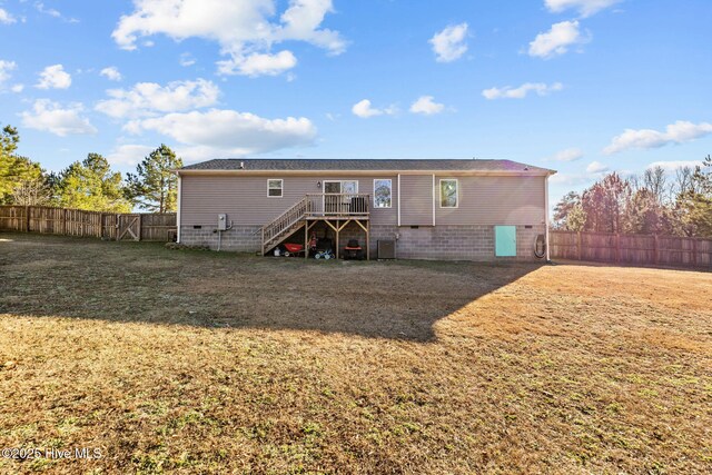 rear view of property featuring a yard and a wooden deck