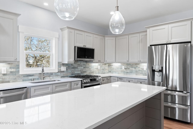 118 SE 9th St, Oak Island, NC 28465 - kitchen with appliances with stainless steel finishes, tasteful backsplash, hanging light fixtures, a sink, and light countertops