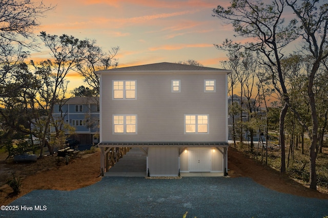 view of front of property with gravel driveway and a carport