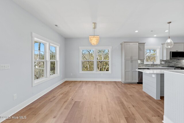 118 SE 9th St, Oak Island, NC 28465 - kitchen with light wood-style floors, baseboards, light countertops, appliances with stainless steel finishes, and backsplash