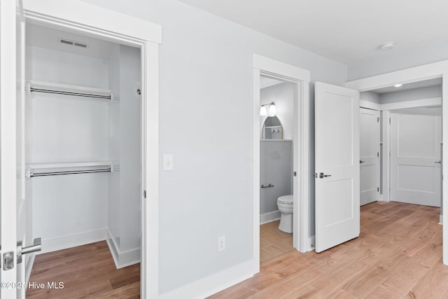 unfurnished bedroom featuring a closet, visible vents, and light wood-style flooring