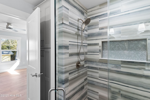 bathroom featuring a ceiling fan, a shower stall, wood finished floors, and a sauna