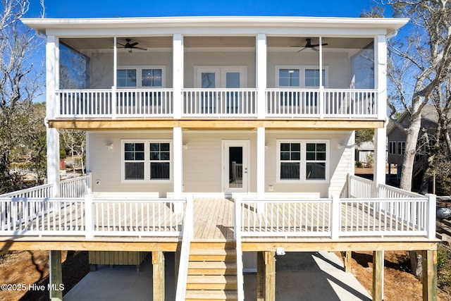 rear view of property with ceiling fan and stairs