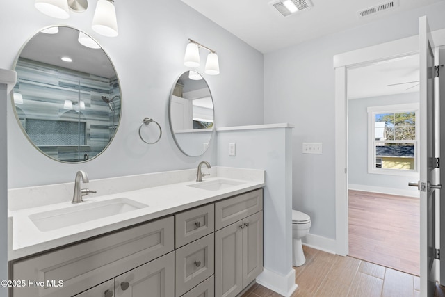 bathroom featuring visible vents, toilet, and a sink