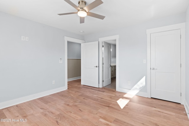 unfurnished bedroom featuring light wood finished floors, connected bathroom, a ceiling fan, and baseboards