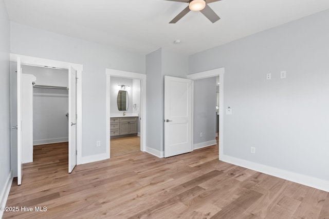 118 SE 9th St, Oak Island, NC 28465 - unfurnished bedroom with baseboards, a walk in closet, light wood finished floors, and ensuite bath