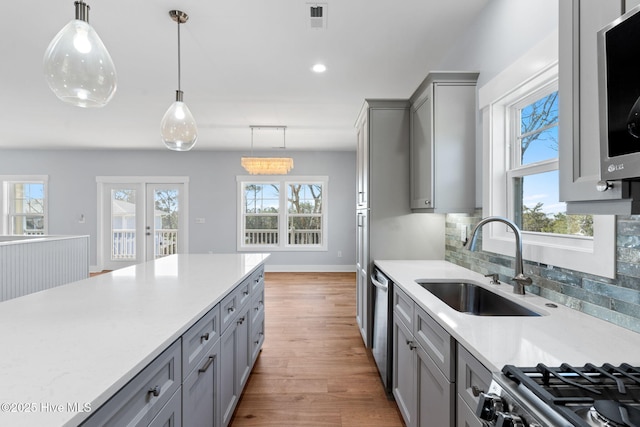 kitchen with visible vents, light countertops, gray cabinets, stainless steel appliances, and a sink