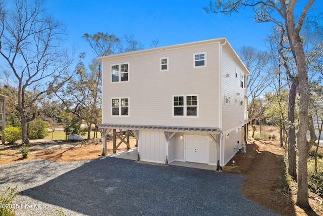 118 SE 9th St, Oak Island, NC 28465 - back of house with board and batten siding and gravel driveway