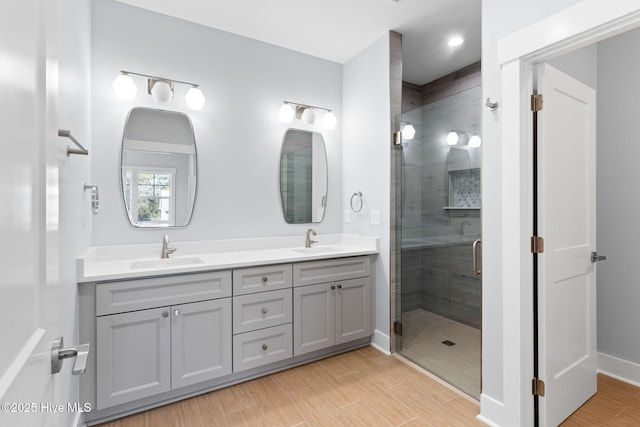 full bath featuring a sink, wood finished floors, and a stall shower