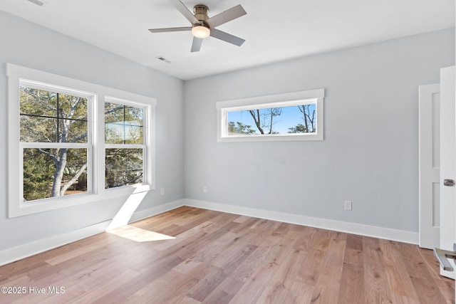 empty room with visible vents, baseboards, a ceiling fan, and light wood finished floors