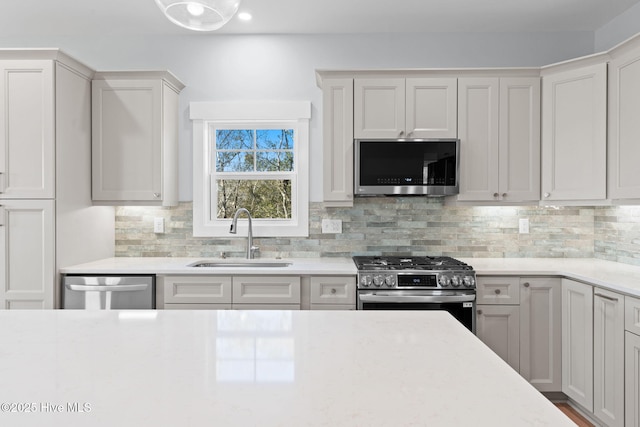 kitchen featuring tasteful backsplash, appliances with stainless steel finishes, and a sink