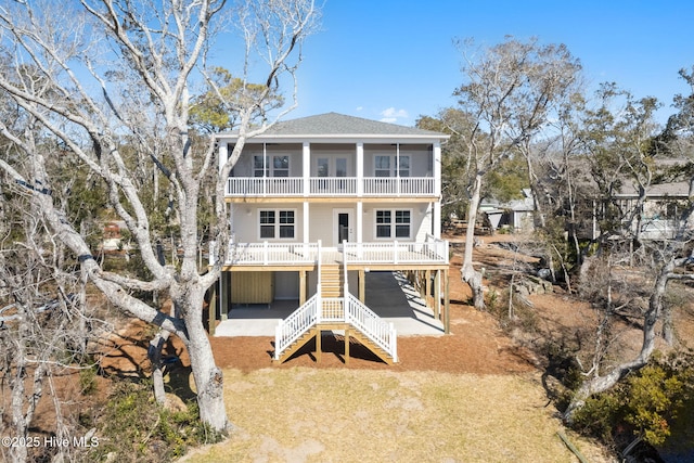 back of house with a yard, a balcony, stairs, and a shingled roof