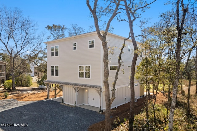 rear view of house with a carport and gravel driveway